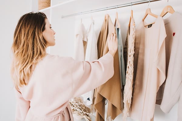 Woman choosing between different clothes in her closet in the process of reinventing her style Woman choosing between different clothes in her closet in the process of reinventing her style