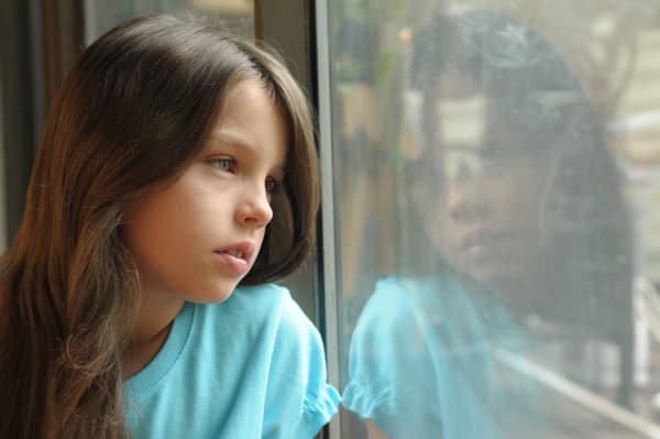 Girl looking out window due to inconsistent visitation