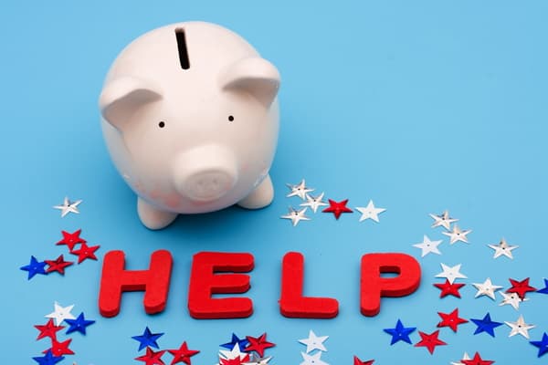 Piggy bank with the word help spelled out below Piggy bank with the word help spelled out below