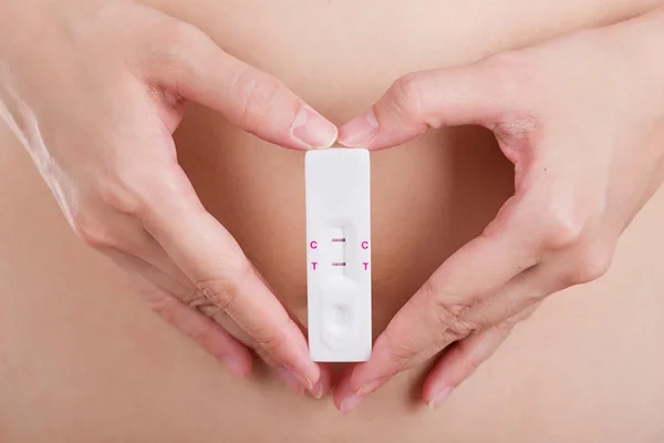 Woman holding a positive pregnancy test