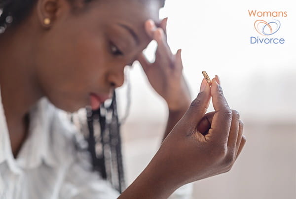 Woman holding wedding ring having to decide whether to separate or divorce Woman holding wedding ring having to decide whether to separate or divorce
