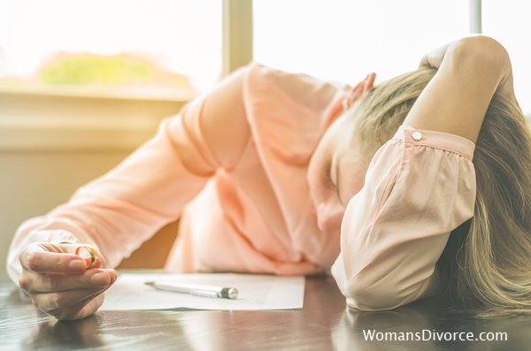 Woman holding her wedding ring about to experience the 5 stages of divorce Woman holding her wedding ring about to experience the 5 stages of divorce