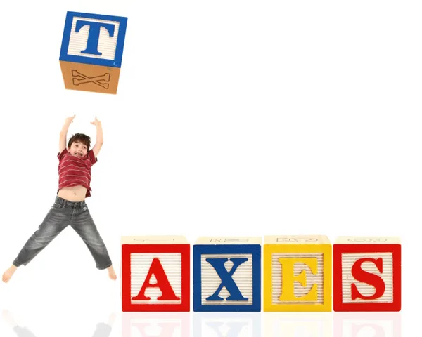Child hold block with the letter T spelling out the word taxes blocks representing child tax credits